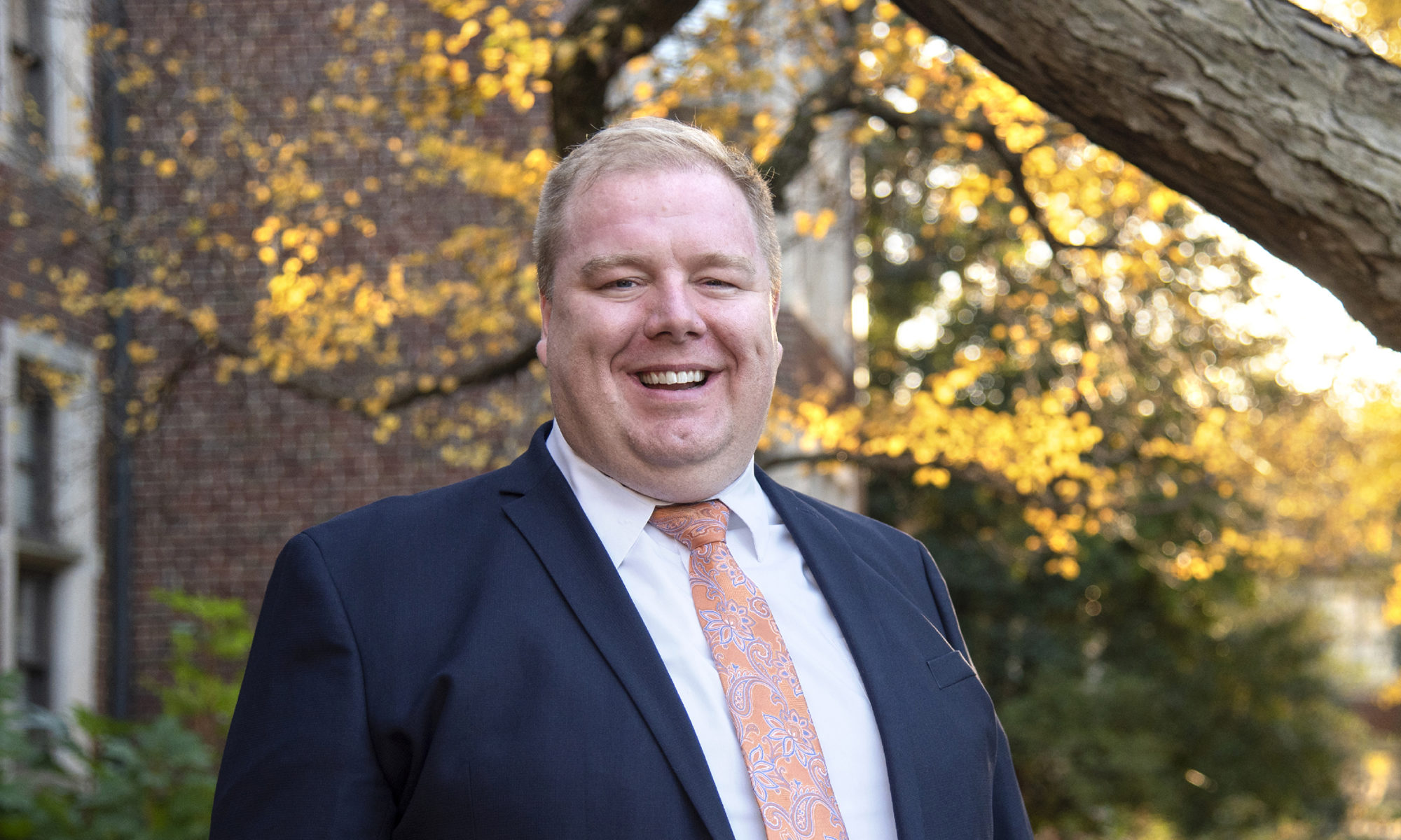 Headshot of Justin Crowe standing under a tree