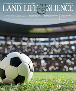 Cover of the Fall/Winter 2022 issue of Land, Life & Science print version, showing a black and white soccer ball on a green turf field in a stadium