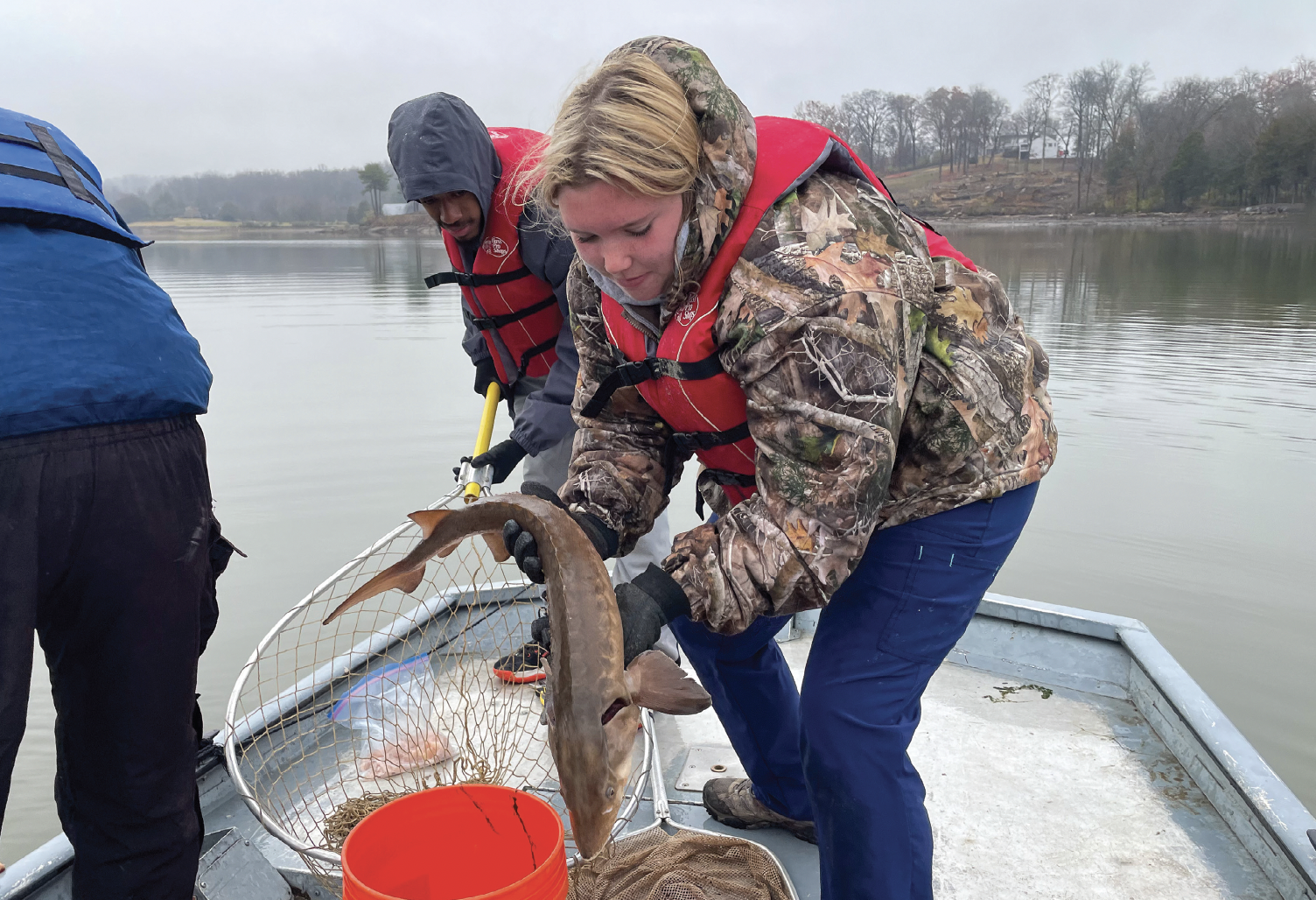 Student holding a lake sturgeon