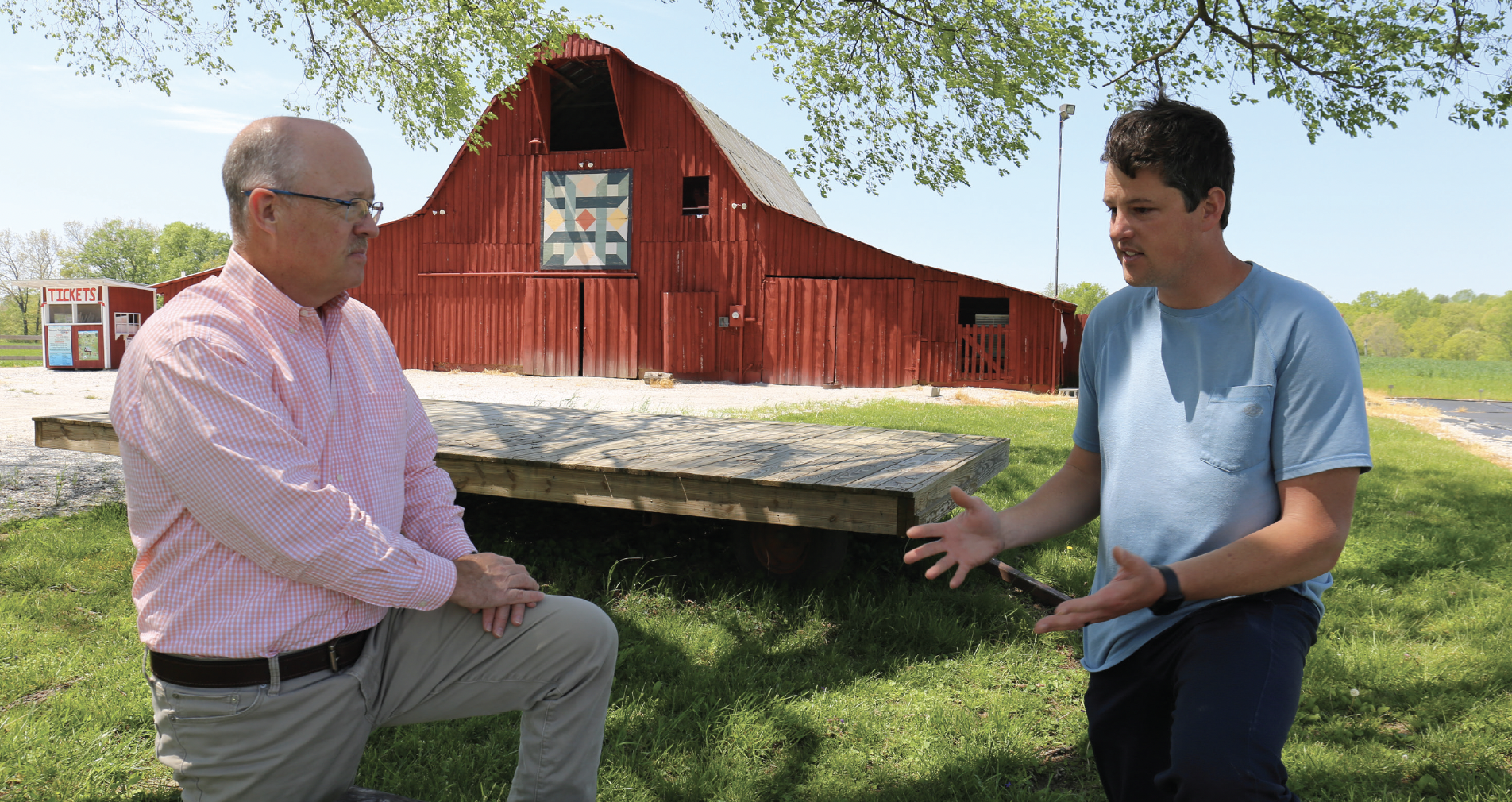 Rob Holland and Andrew Dixon talking in front of a barn