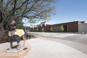 A statue of Smokey and the new Teaching and Learning Center building