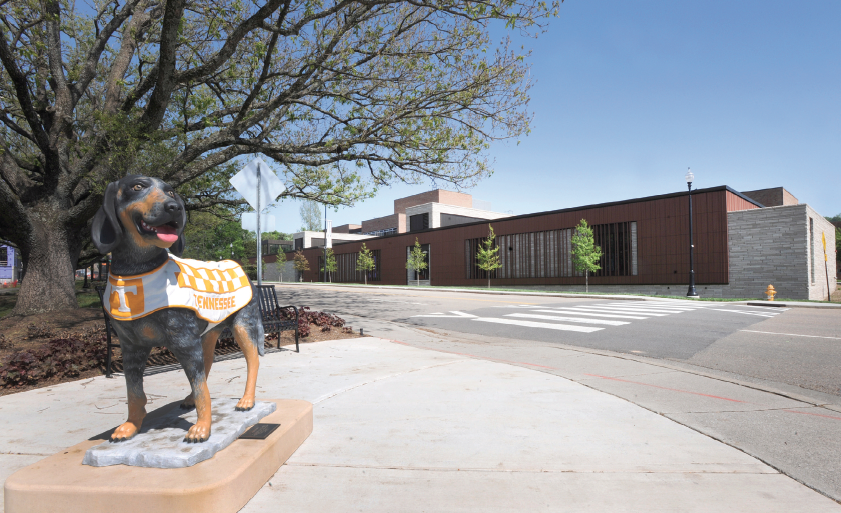 A statue of Smokey and the new Teaching and Learning Center building