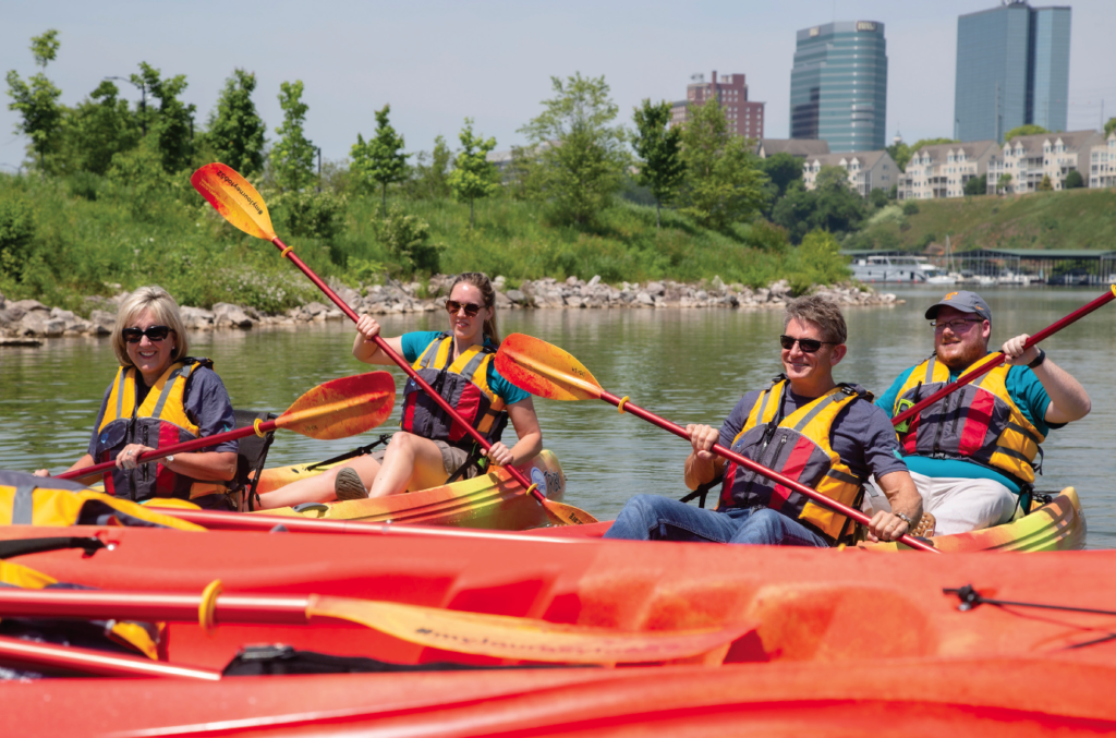 Four people paddling in kayaks