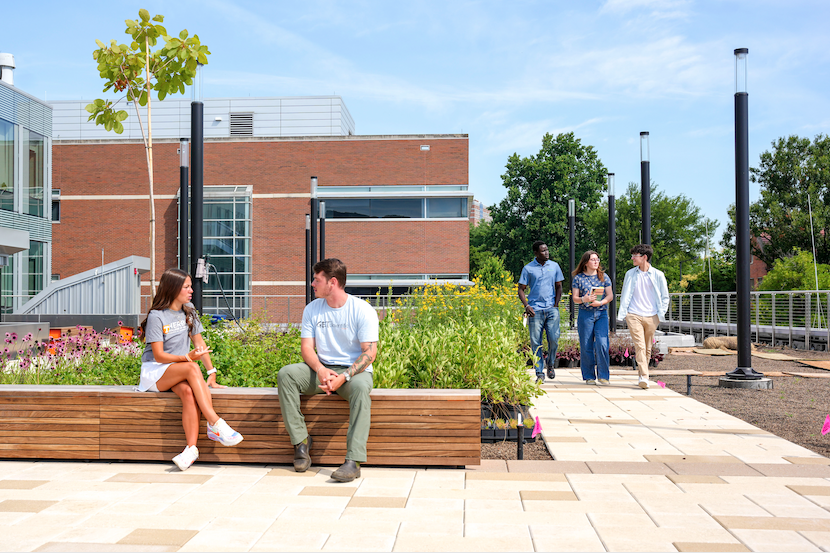 Students sitting where there is a green space on the roof of the new building