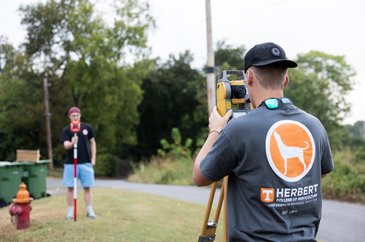 Students working with land survey equipment