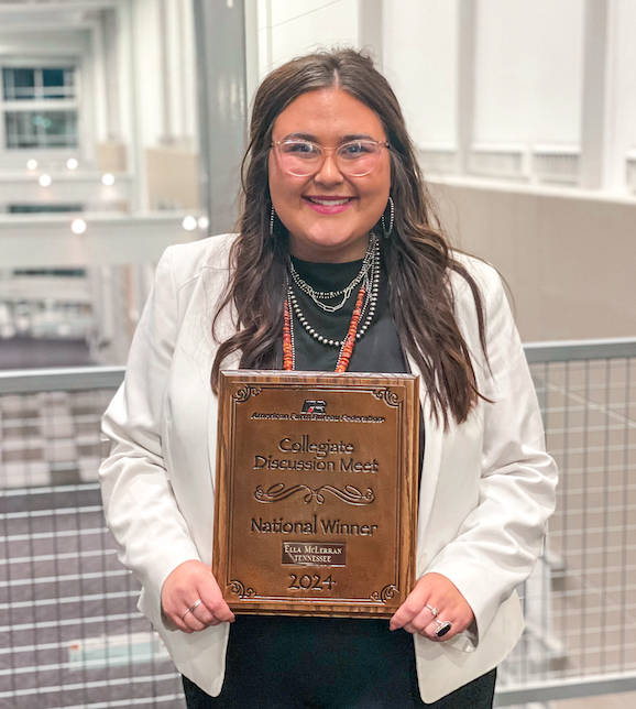 Ella holding up her national winner award