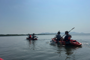 Students in kayaks paddling on a river