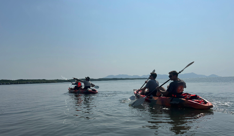 Students in kayaks paddling on a river