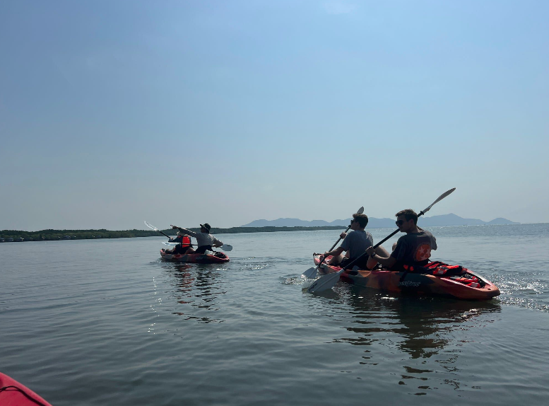 Students in kayaks paddling on a river