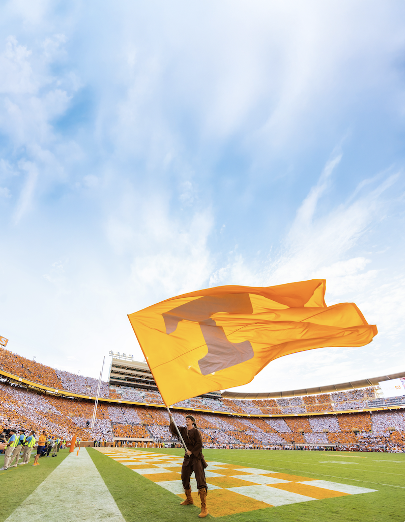 A student as Davy Crockett waving the Power T flag in the end zone of Neyland Stadium