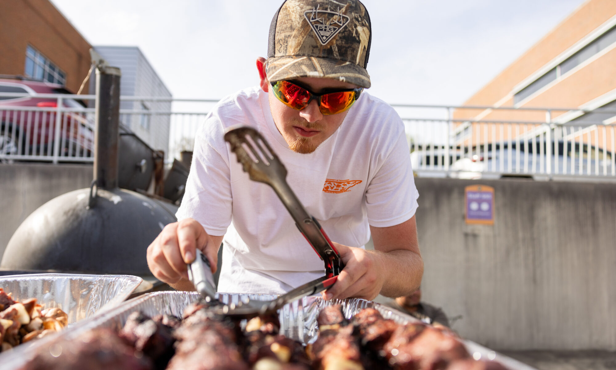 A person checking the temperature of cooking meat