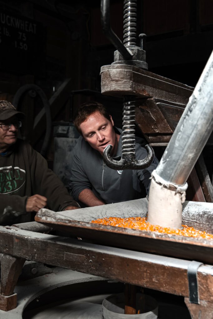 Two people examining corn in the distilling process