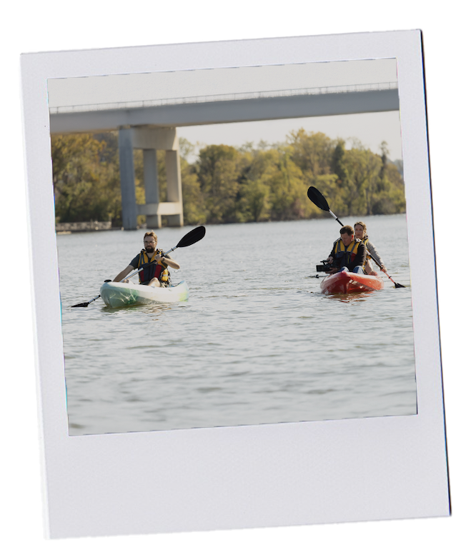 Polaroid style image of two kayaks on the Tennessee River with two paddlers and one person holding a video camera
