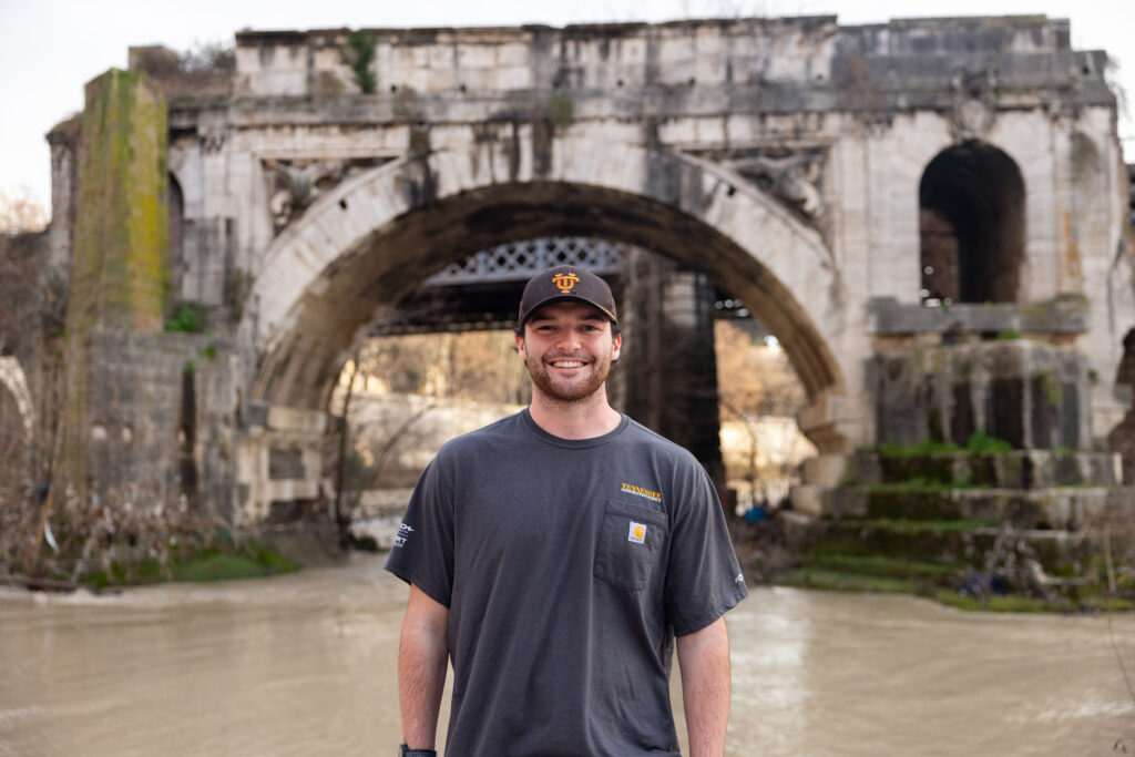 Construction science and management senior Nicholas Dunn stands in front of Pons Aemilius, the oldest stone bridge in Rome built in the second century BC