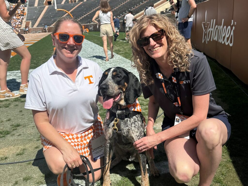 Members of Smokey’s team, Kaleena Scarbro, left, and behaviorist Julia Albright pose with Smokey XII during the 2026 Orange and White Game.
