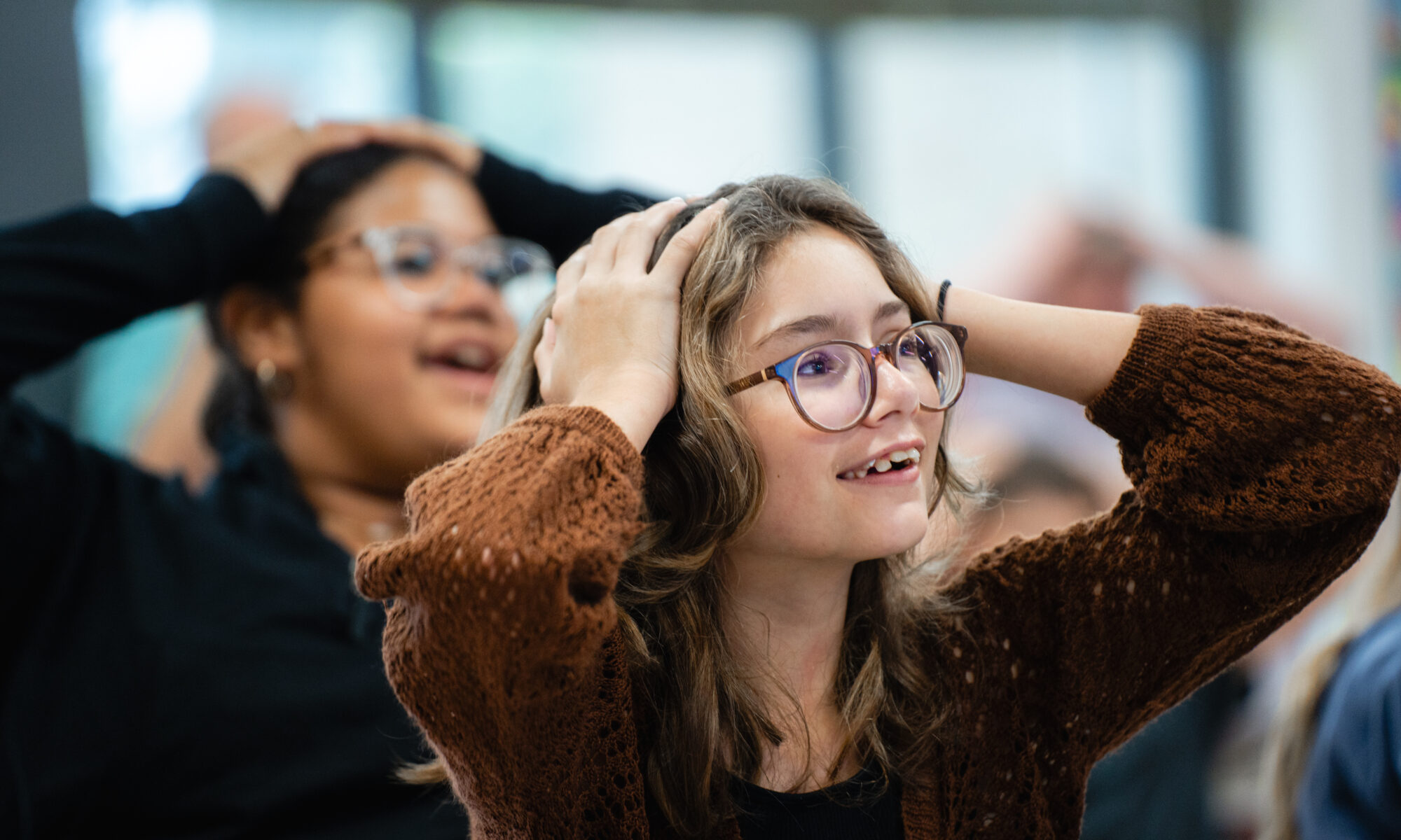 Two students with their hands on their heads engaged in a STEM activity